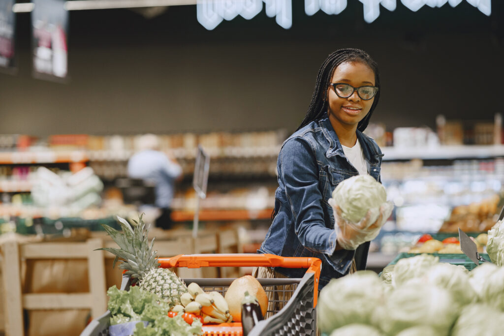 African woman with shopping cart. Girl in a supermarket.